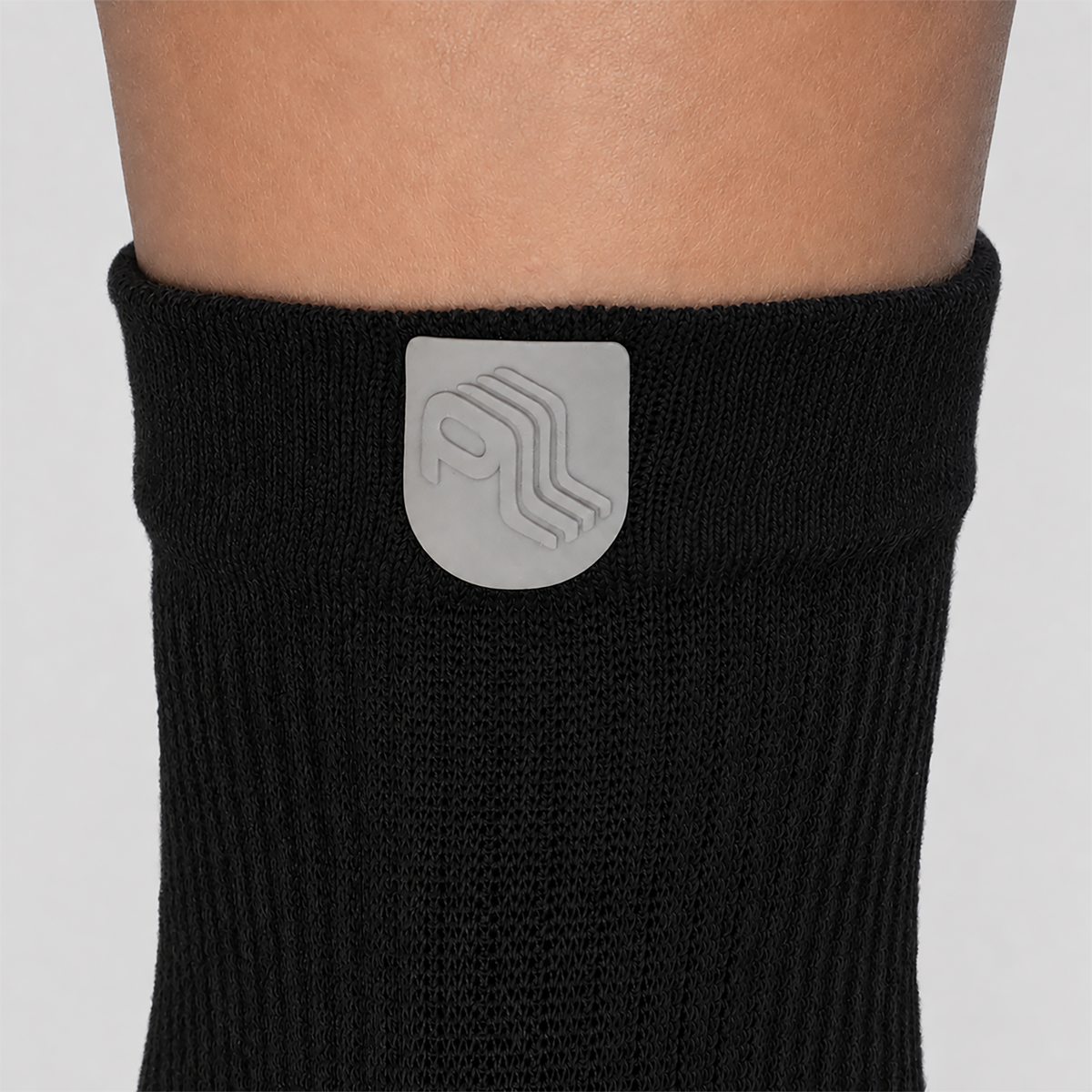 Close-up of the Public Locomotion emblem on the cuff of a black All-Day Toe Sock.