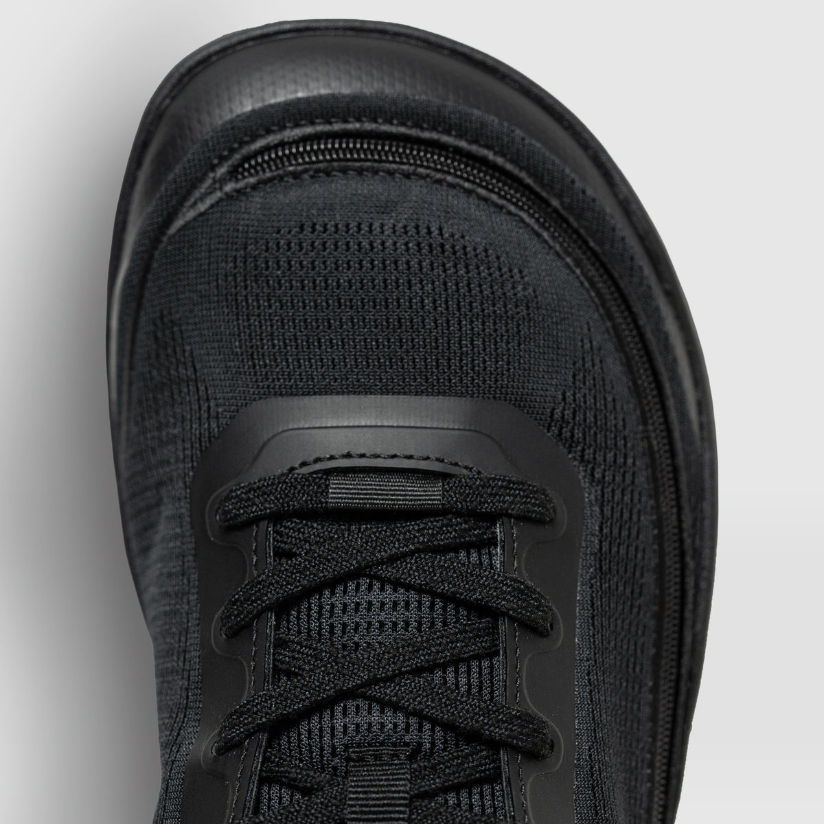 Top view of a black Arc trainer, showing the rounded toe box and zipper.