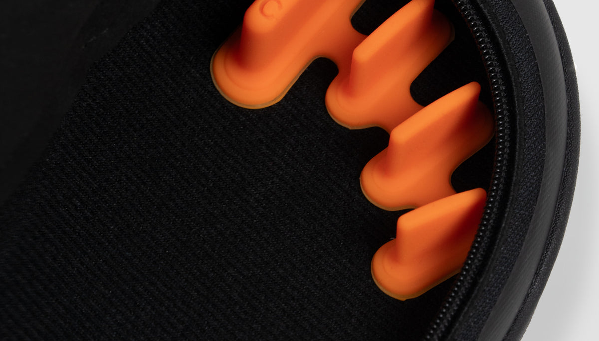 Close-up of an orange FeetFormer attached to the insole of a black Arc trainer.