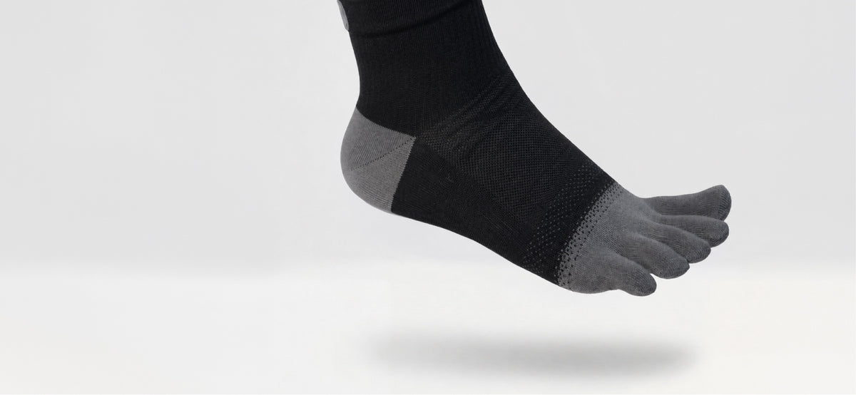 Black All-Day Toe Sock with gray toe pockets and heel, shown on a foot.